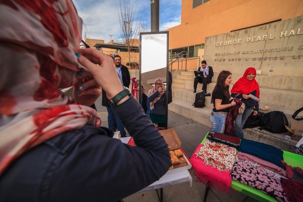 Graduate Student Kayla Street arranges her hijab in front of a mirror at Albuquerque World Hijab Day. The event encouraged women to try on a hijab for the day, as well as ask questions about Islam.