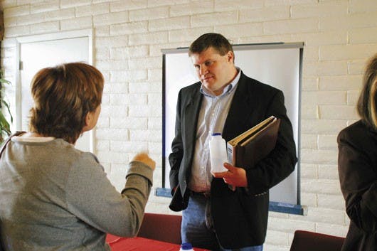 Quentin Chandler from the Greater Albuquerque Chamber of Commerce, who spoke against the Quality of Life tax during a debate, listens to an audience member who is in favor of the tax. The debate was sponsored by the League of Women Voters at the Courtyard