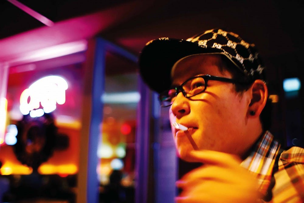 UNM student Aaron Sanchez smokes a cigarette in front of Brickyard Pizza on June 16. A statewide ban went into effect June 15 that prohibits smoking in bars, restaurants and most indoor workplaces.