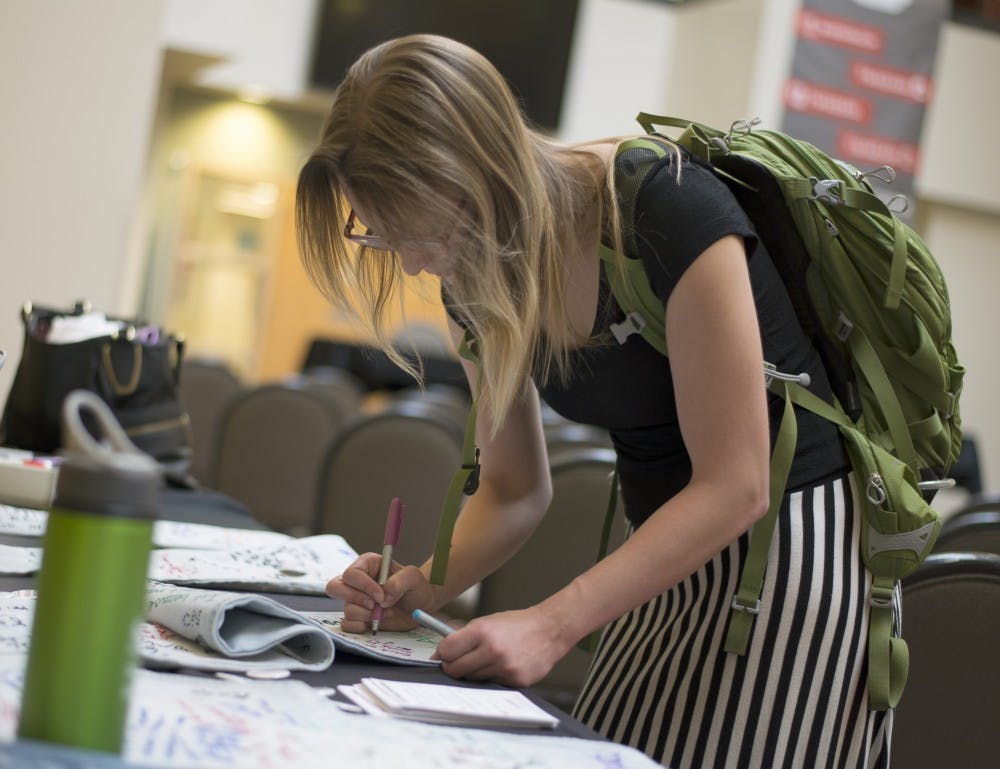 Samantha Ascoli writes a message on a pair of jeans for Denim Day in the SUB Atrium as a part of Sexual Assault Awareness Month. Organizers of Denim Day encouraged supporters to leave a pair of pants in the Atrium where others could write positive and motivational quotes on them. 