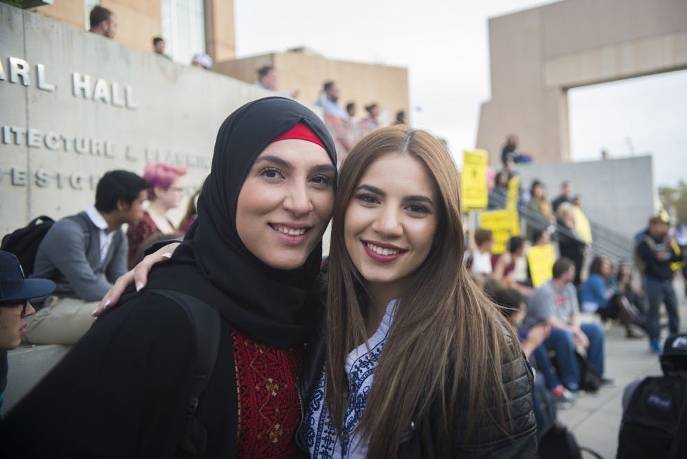 UNM Muslim Student Association President Serene Akkad, left, and MSA member Bayan Jaber attend a march against hate in front of the UNM Bookstore on Wednesday, Nov. 16, 2016.