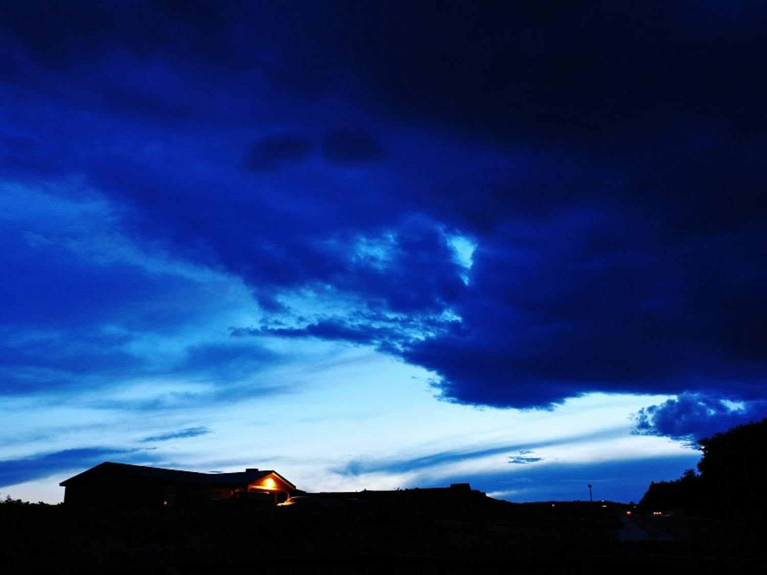 	Abigail Ramirez 
Colliding with the Night 
Colors from a sunset and thunderstorm mix over the Rio Rancho sky, turning the clouds shades of blue and black. The cold breeze made it a nice night to stay indoors by the fire reading a novel. 