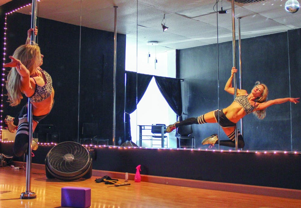 Southwest Pole Dancing owner and director Brynlyn Loomis demonstrates the technique of pole dancing at her studio on Thursday afternoon. Loomis has been involved in pole fitness for over seven years and trained at New York Pole Dancing in New York. 