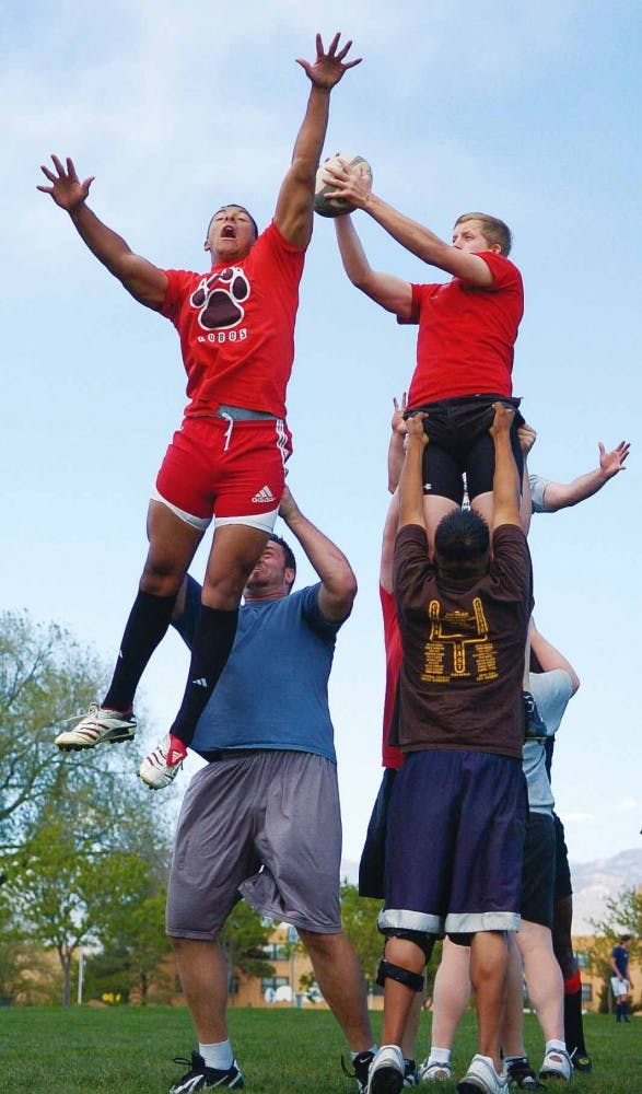 Corey Mohlhenrich, left, and Jason Foskey get hoisted by teammates during a rugby practice at Johnson Field on Wednesday.
