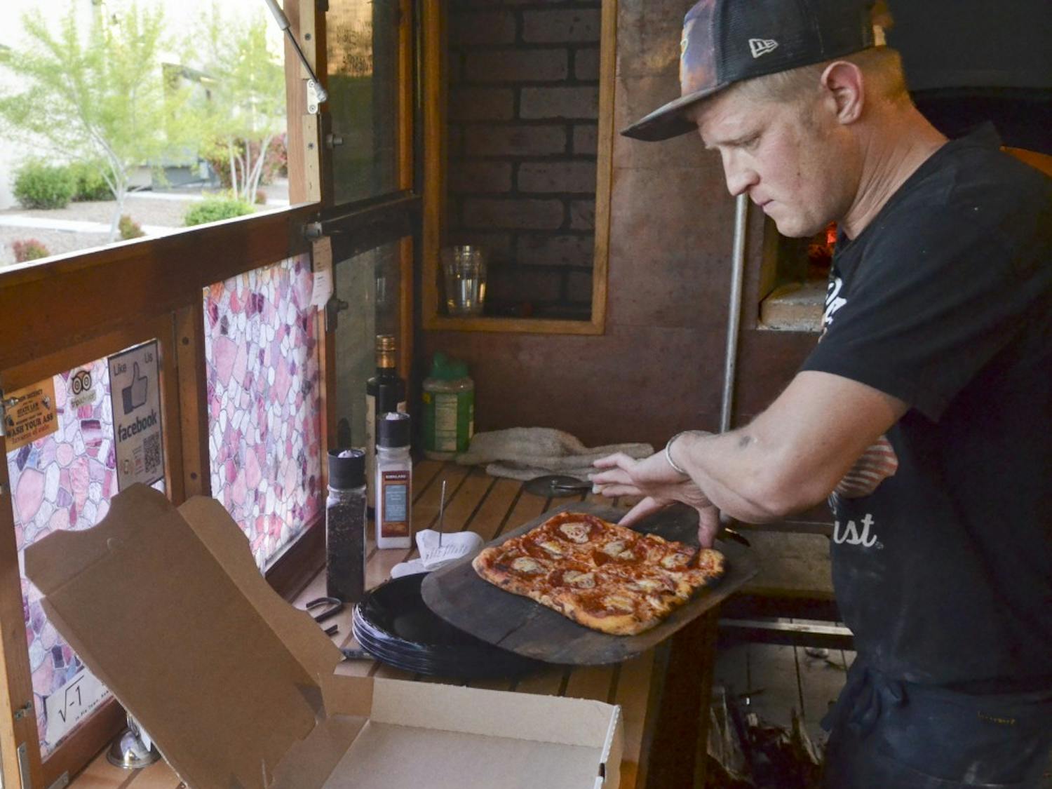 Louis Mentillo, one half owner operator of a-dough-be pizza prepares a pepperoni mushroom pizza to go on Wednesday evening at the Ridgeview Park. A-dough-be pizza is a 14 month old local business that specializes in homemade pizza using a wood burning oven in a mobile food truck.