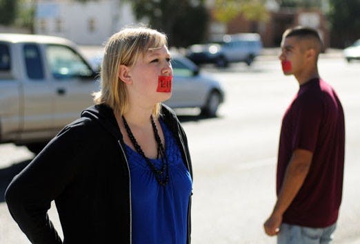 Megan Webb prays in front of Planned Parenthood on San Mateo Boulevard on Saturday. Webb and Andrew Rel, right, are part of the worldwide silent prayer movement Bound4LIFE, which seeks to stop abortion at a local level.