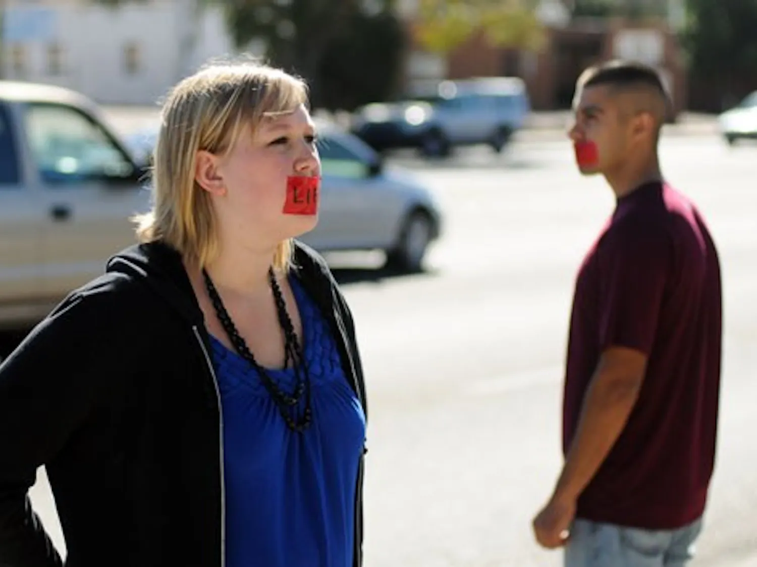 Megan Webb prays in front of Planned Parenthood on San Mateo Boulevard on Saturday. Webb and Andrew Rel, right, are part of the worldwide silent prayer movement Bound4LIFE, which seeks to stop abortion at a local level.