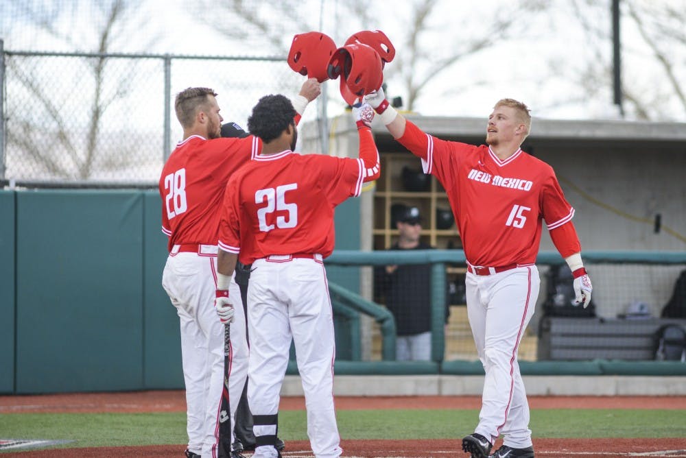 Sophomore Jared Mang is congratulated by teammates as he walks over home plate during the Lobos match against Bringhmaton Feb. Sunday, 19, 2017 at Santa Ana Star Field. The Lobos will play in a three game series against Air Force Academy this Friday.