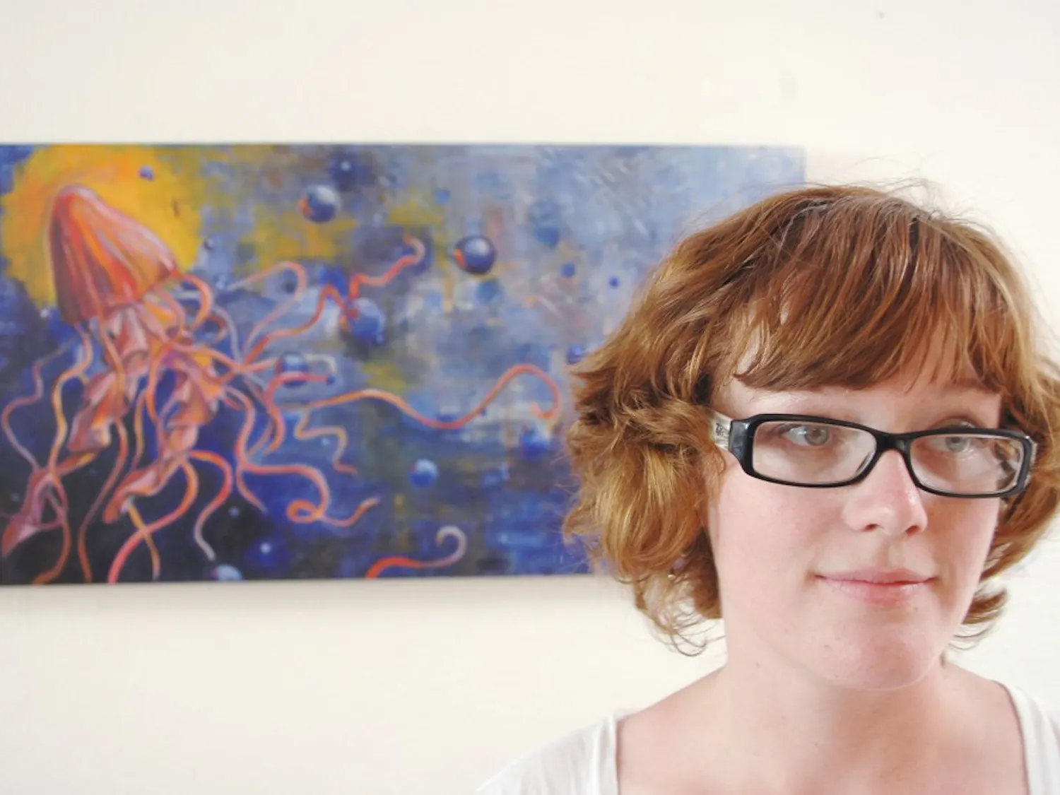 Jessie Hudson, a painter who is finishing up her fourth year majoring in studio art, watches the patrons of Winning’s Coffee Co. in front of one of her paintings. See page 14.