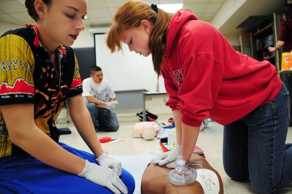 	J.J. Bear, left, and Sara Armstrong practice CPR and other life-saving techniques during their Health Education class in Johnson Gym on Wednesday. They are training to be certified in CPR and automated external defibrillators (AED).