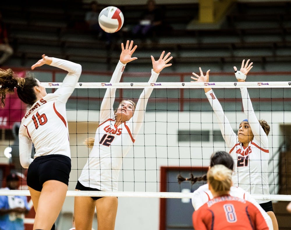 Senior Cassie House, 12&nbsp;and redshirt sophomore Mariessa Carrasco attempt to block a attack from UNLV Tuesday Oct. 11, 2016 at Johnson Center Gym. The Lobos lost to Utah State 3-1.