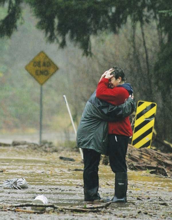 Amy Anderson, right, hugs Melanie Tapia after a flash flood destroyed their restaurant near Olympia, Wash., on Monday.