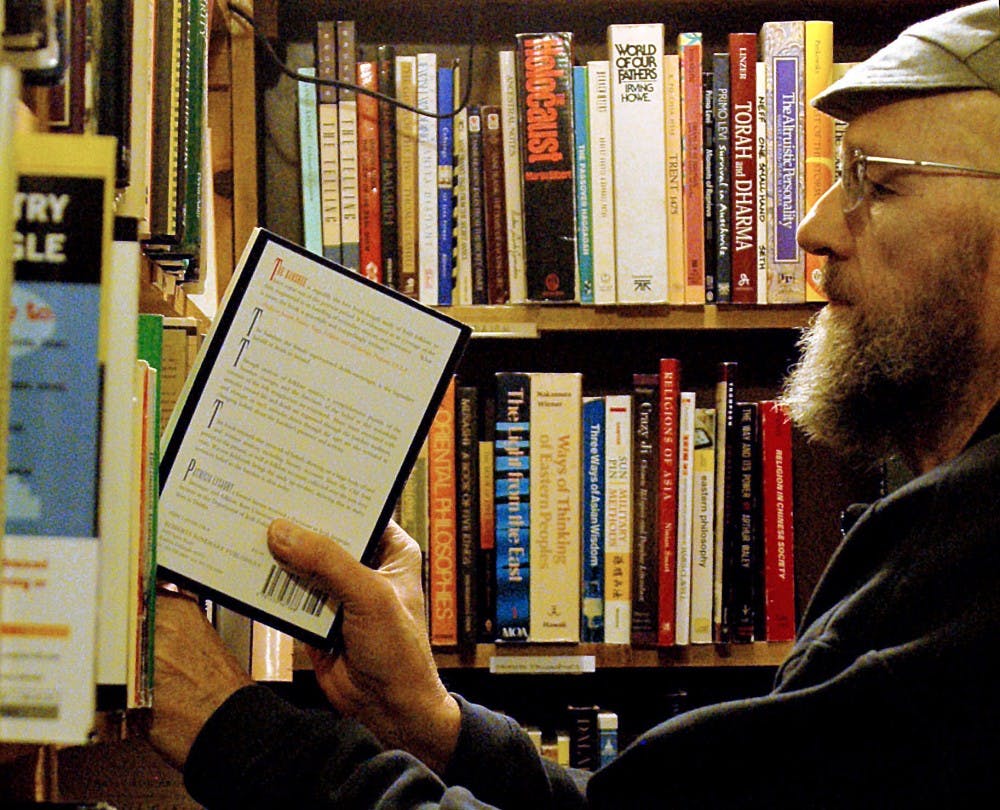 	Asa Mullins puts away a book in Bird Song on Jan. 23. Bird Song, one of several campus area used bookstores, has had to deal with a structure fire and other economic issues in order to stay afloat.