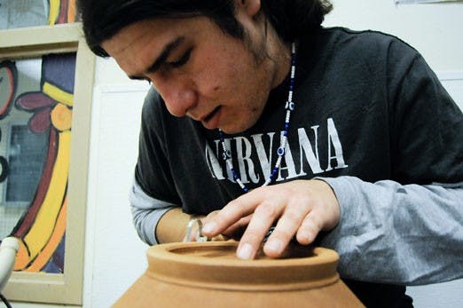 Zane White works on a pottery piece to sell in the ASUNM Arts & Crafts Fair, which starts today at 11 a.m. 