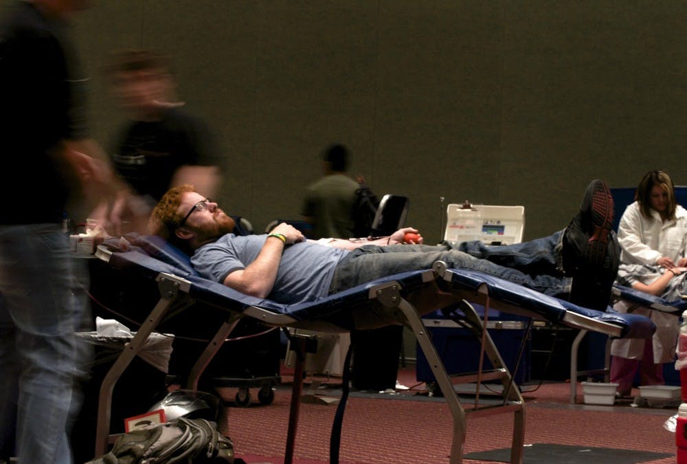 	Student David Funnell lies on the bed while donating plasma. United Blood Services continues its on-campus blood campaign today.