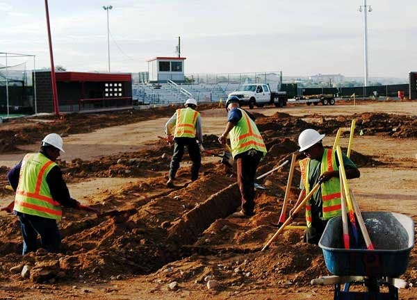 Construction crews work at the UNM Softball Complex on Tuesday. The $1 million project will include new dirt and grass, a rain-resistant warning track, new lighting and extra seating. 