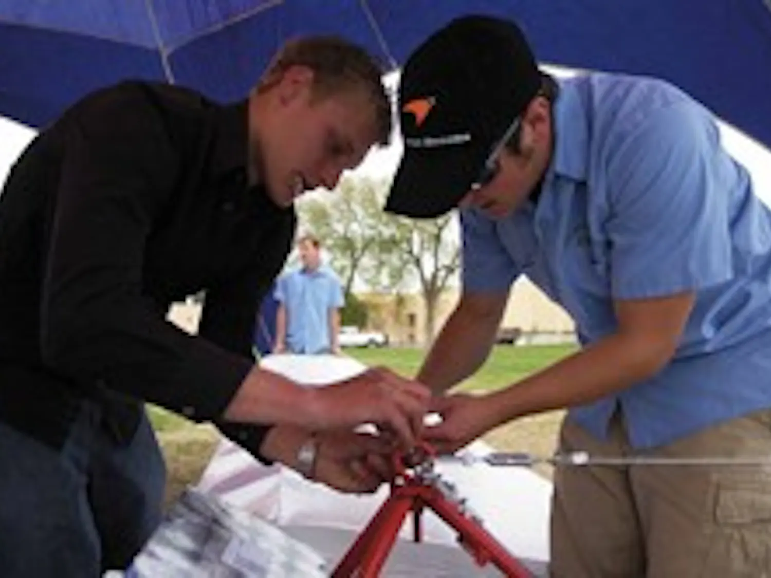 Chris Keaty, left, and pilot Austin Wetsch, team members of El Vuelo Del Lobo, work on their Flugtag glider during Fiestas on Saturday at Johnson Field.