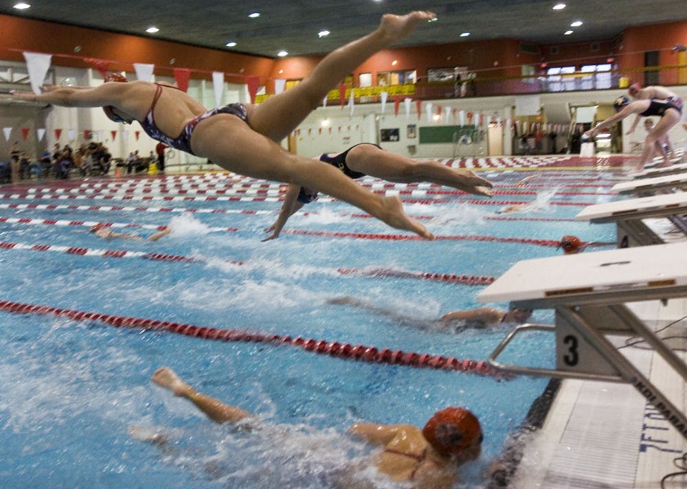 	UNM swimming and diving team members dive into the pool during a race against Colorado State at Thursday’s swim meet in Armond H. Seidler Natatorium. 