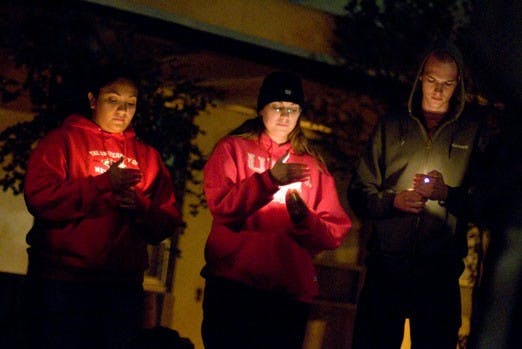 Alicia Sedillo, left, Kathy Dolan and Corey Davis pray during a candlelight vigil Saturday at the Aquinas Newman Center. 