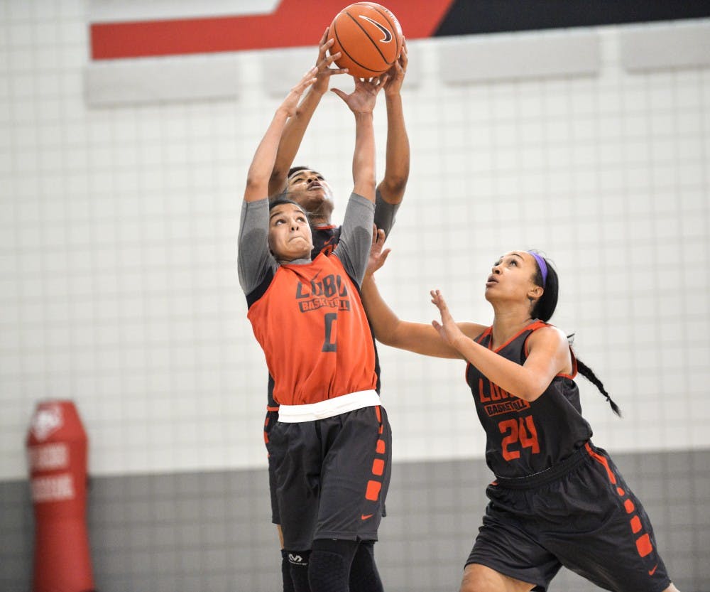 Cherise Beynon (0) reaches past Khadijah Shumpert and Jayda Bovero (24) during their second practice of the season on Oct. 6 at the Davalos Training Center. The Lobo Howl event will be held at WisePies Arena this Friday at 6 p.m..