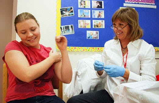 Ashley Norris, left, gets a flu shot from nurse Jo Antreasian in the Student Residence Center on Oct. 14. 
