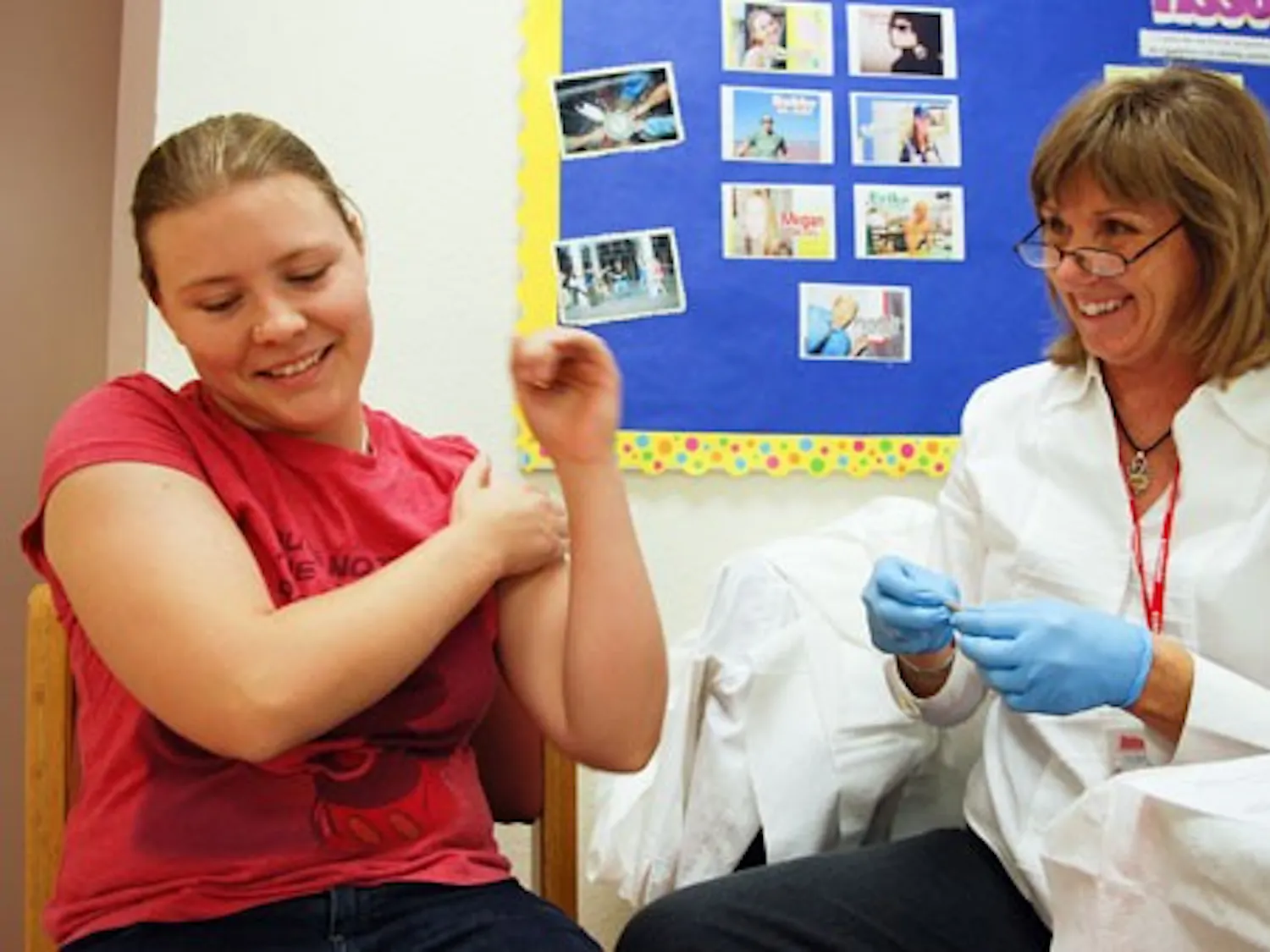 Ashley Norris, left, gets a flu shot from nurse Jo Antreasian in the Student Residence Center on Oct. 14.