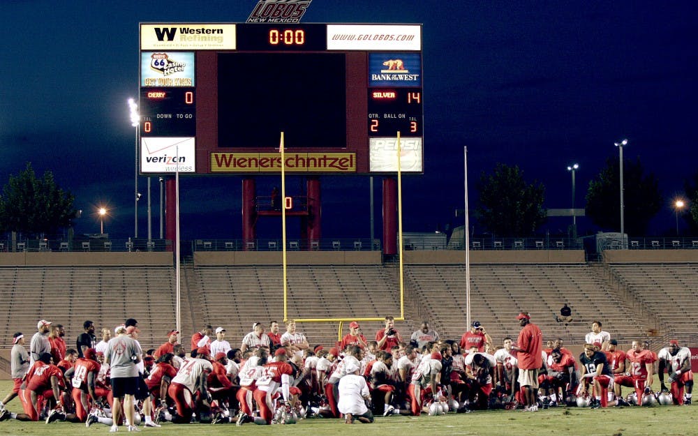 	Head coach Mike Locksley and his team gather at midfield after a recent practice. The Lobos will head to College Station, Texas, to face Texas A&amp;M on Saturday.
