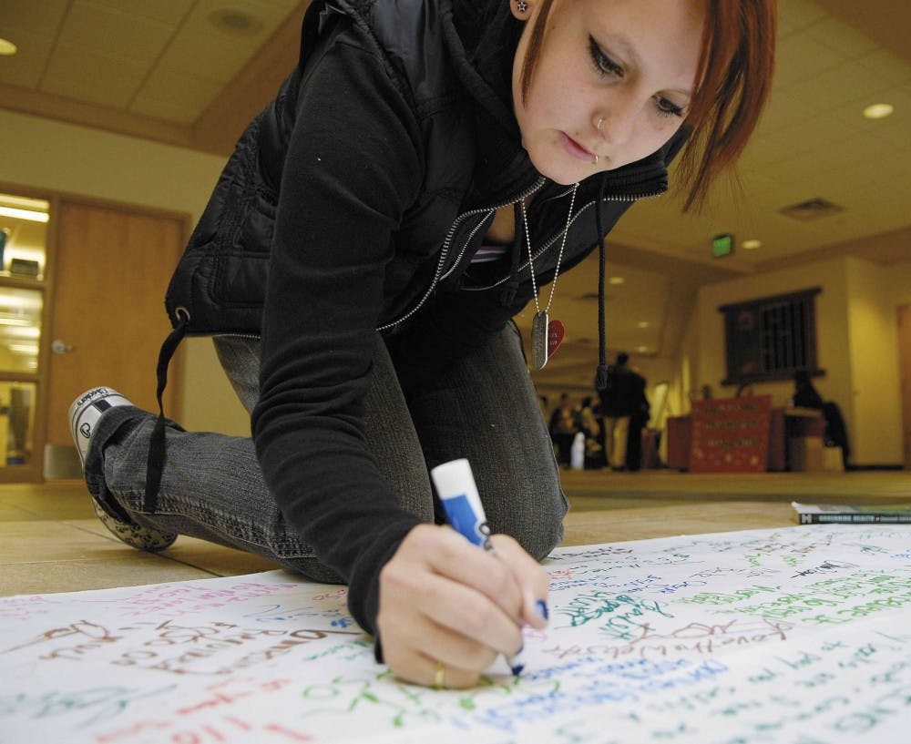 Student Ashley Glasrud signs an NMPIRG petition in the SUB that will be sent to the McGraw-Hill textbook publisher. Students were asked to sign the paper with the amount they spent on textbooks this semester. Glasrud said she spent more than $400 on textb