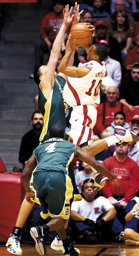 Colorado State's Stuart Creason blocks UNM's Jamaal Smith's jump shot during the Lobos' 88-79 loss at The Pit on Saturday.