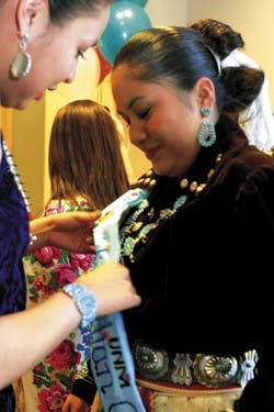 Miss Indian New Mexico Fern Spencer, left, helps contestant Elesha Jim with last-minute preparations before Jim appeared onstage during the Miss Indian UNM pageant in the SUB Ballroom on Monday. Jim took runner-up in the event while fellow Navajo Terraden