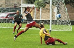 UNM defender Ashley Lowery, center, blocks a shot in a scrimmage during practice Monday at Robertson Field.