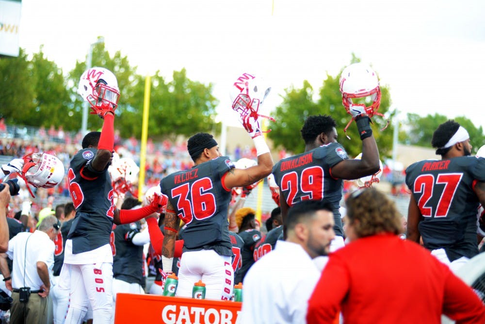UNM football players raise their helmets in a game against San Jose State at University Stadium on Saturday, Oct. 1, 2016. After going 8-4 on the year, New Mexico will play in the Gildan New Mexico Bowl for the second consecutive season on Dec. 17 in Albuquerque.