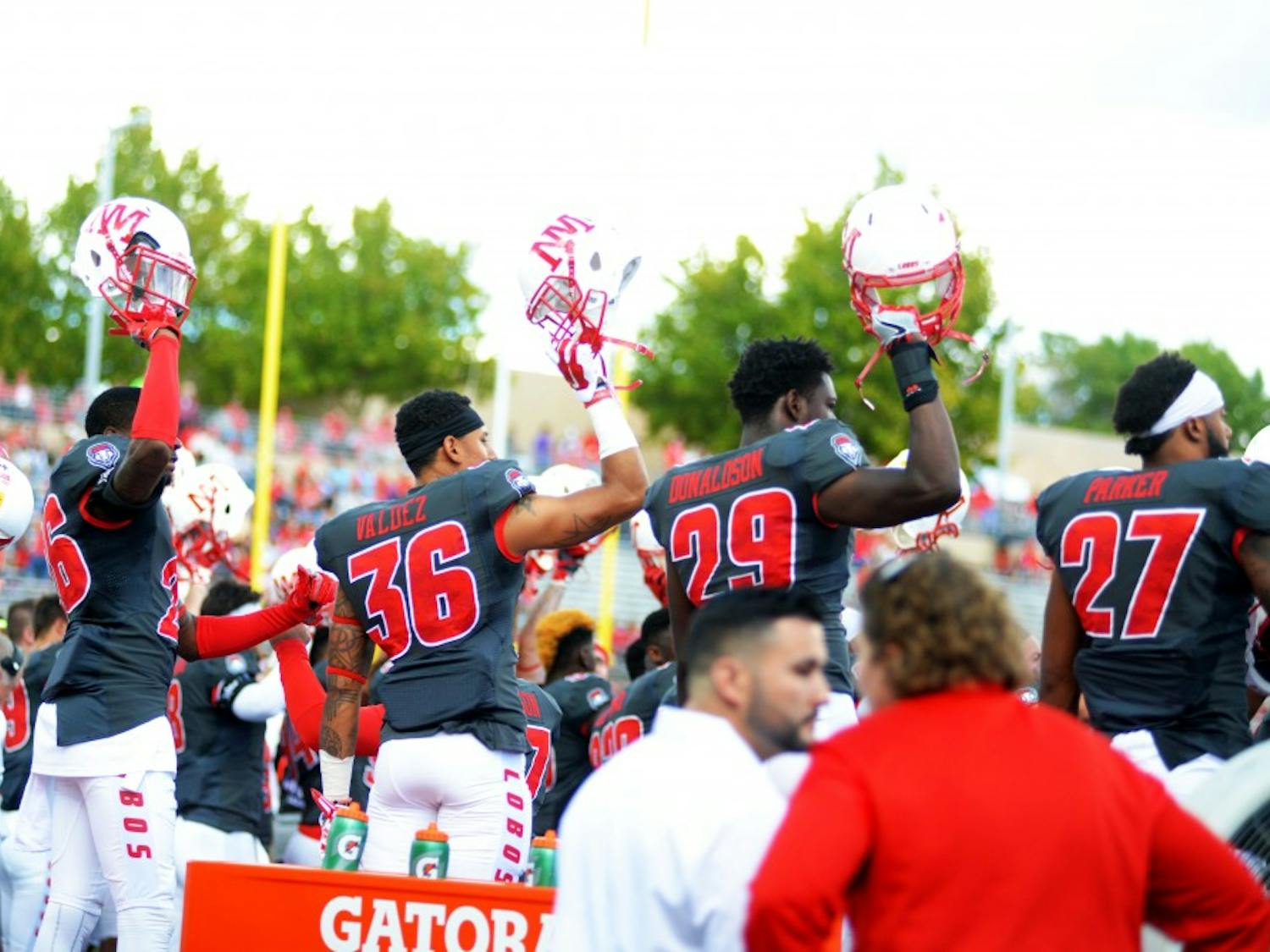 UNM football players raise their helmets in a game against San Jose State at University Stadium on Saturday, Oct. 1, 2016. After going 8-4 on the year, New Mexico will play in the Gildan New Mexico Bowl for the second consecutive season on Dec. 17 in Albuquerque.