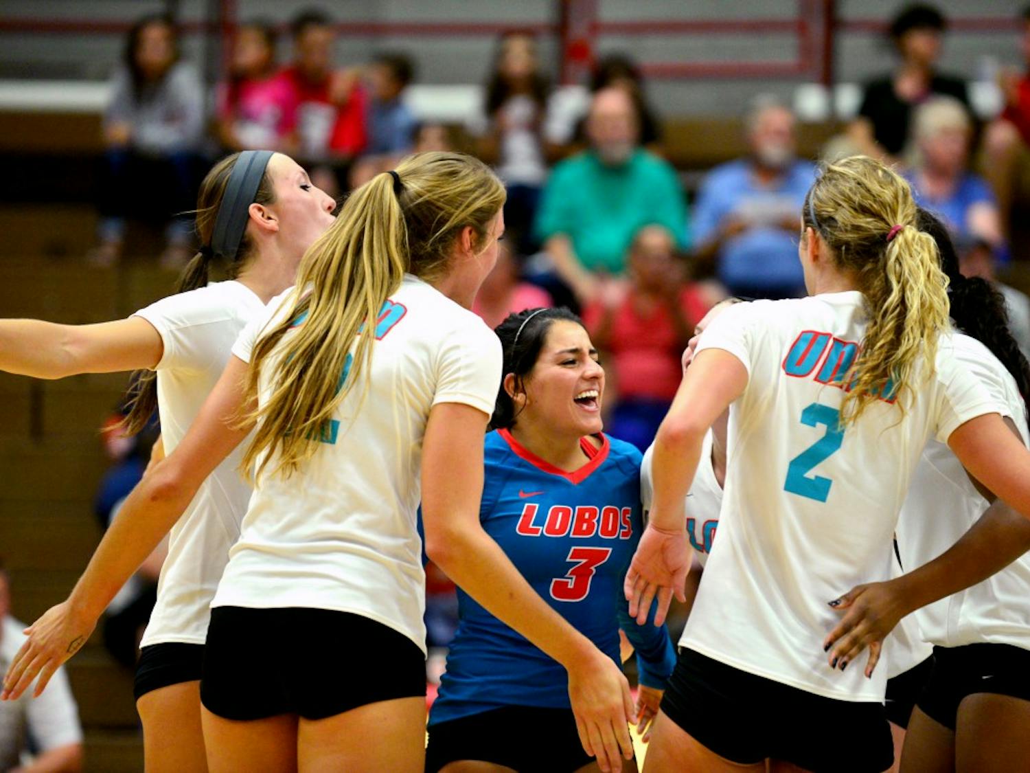 UNM libero Mercedes Pacheco is surrounded by her teammates after scoring a point against Santa Clara on Sept. 4. As a defensive specialist, Pacheco’s role for the Lobos is a key one for the team.