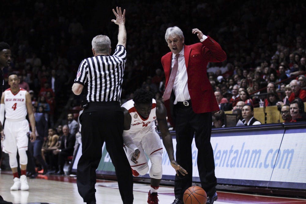 Lobo Jordan Hunter squeezes himself in between a referee and Lobo coach Craig Neal during Saturday nights game against SDSU.&nbsp;