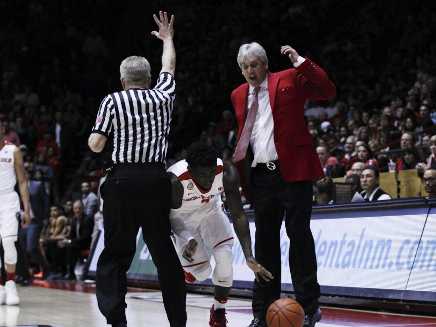 Lobo Jordan Hunter squeezes himself in between a referee and Lobo coach Craig Neal during Saturday nights game against SDSU. 
