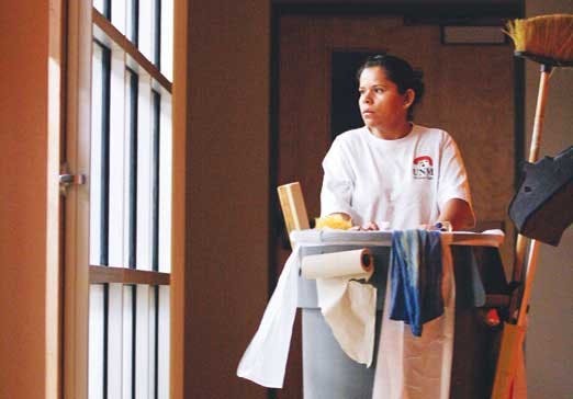 Magdalena Vela, a custodian, makes her rounds at the Communication and Journalism building Tuesday evening. 