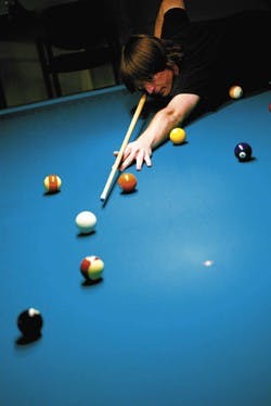 Student Geoffrey Reimann plays billiards in the SUB's game room Tuesday. TechSmith managed the game room from August 2005 to July 2006.
