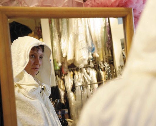 Albuquerque resident Stephanie Atencio looks in a mirror after trying on a robe for a Halloween costume Monday at the Off Broadway Vintage Clothing store on Central Avenue.      
