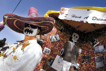 Alamosa Elementary School teacher Jenny Beyss stands next to an altar dedicated to the Rev. Martin Luther King Jr. before the Dia de los Muertos Marigold Parade and Celebration in the South Valley on Sunday.