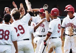 Lobo baseball players congratulate teammate Ian Hollick, 10, after he hit a home run during Saturday's doubleheader against Utah at Isotopes Park.  
