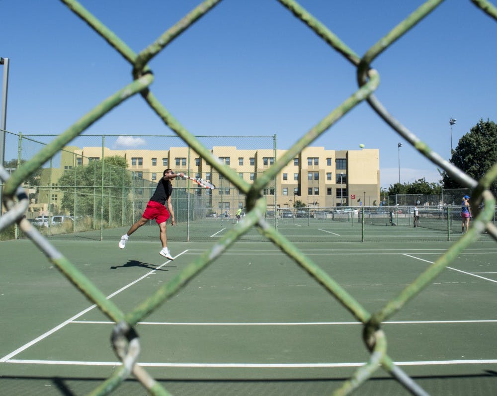 Thien Pham returns a shot against Pouria Khanbolouki at the tennis courts north of the Johnson Center on Friday afternoon. Intramural tennis is free and open to all enrolled students, faculty and staff.