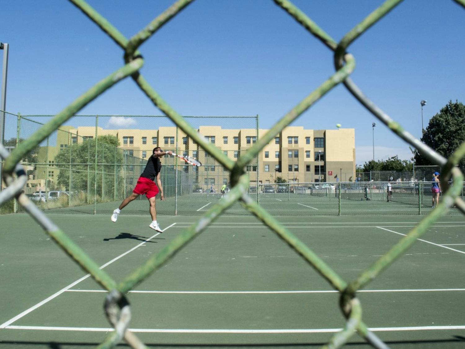 Thien Pham returns a shot against Pouria Khanbolouki at the tennis courts north of the Johnson Center on Friday afternoon. Intramural tennis is free and open to all enrolled students, faculty and staff.