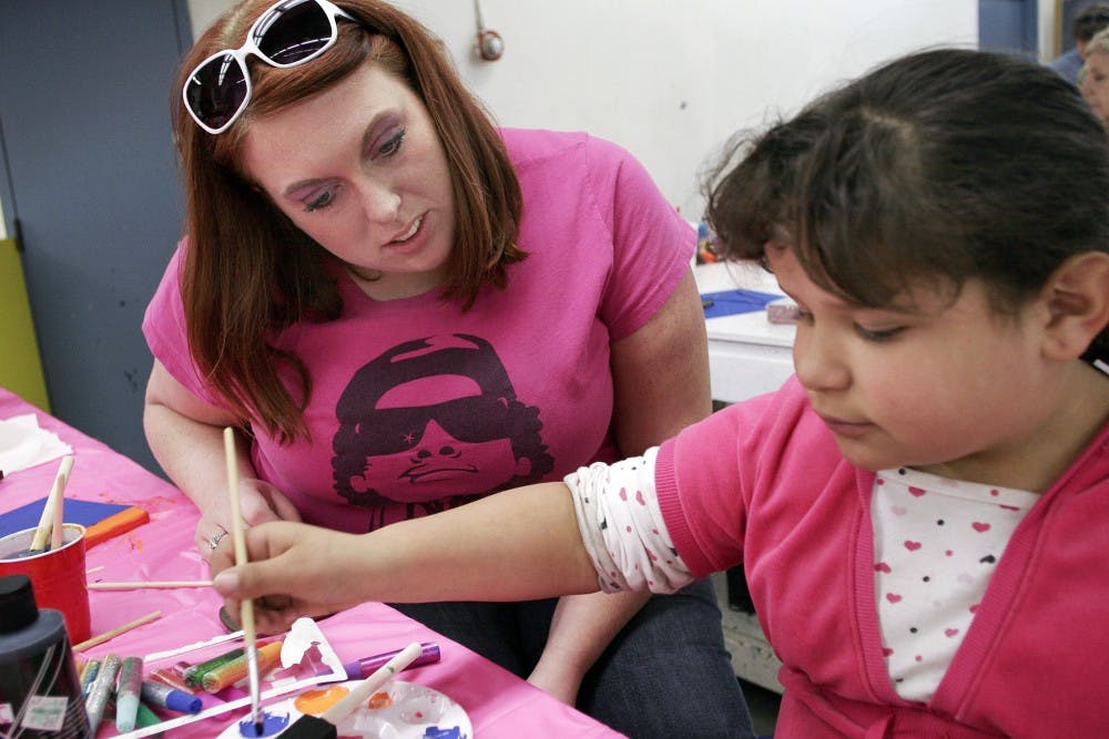 	Virginia Graumann, left, and Destinie Murphy discuss what colors to use on their paintings at the Art Building on Saturday. The two are matches in the Big Brothers Big Sisters program and participated in an arts and crafts day put on by the program.