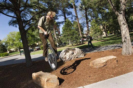 Student Zachary Carris jumps off a rock on his unicycle near the Duck Pond on Wednesday.