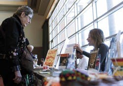Maureen Wright, left, talks with Defenders of Wildlife's Lisa Hummon at the "Seeds of Change: The Earth Charter and Human Potential" exhibit in the SUB Ballroom on Monday. The exhibit profiled how humans have devastated the Earth from consumption practice