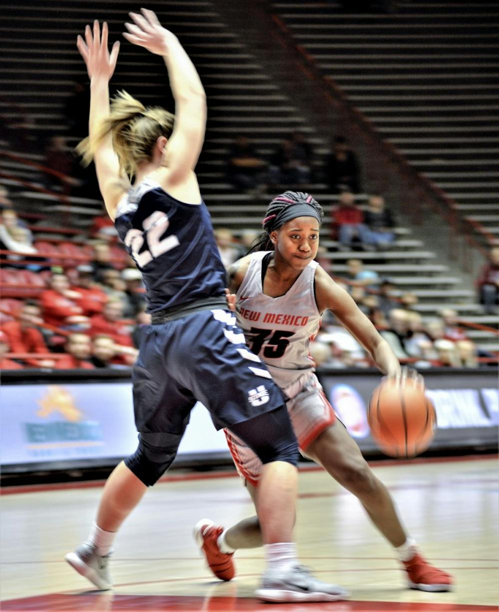 Madi Washington of the New Mexico women's basketball team attempts to drive past Utah State's Rachael Brewster, No. 22, during the third quarter of Wednesday's game between New Mexico and Utah State. The Lobos cruised to an 80-47 victory. &nbsp;