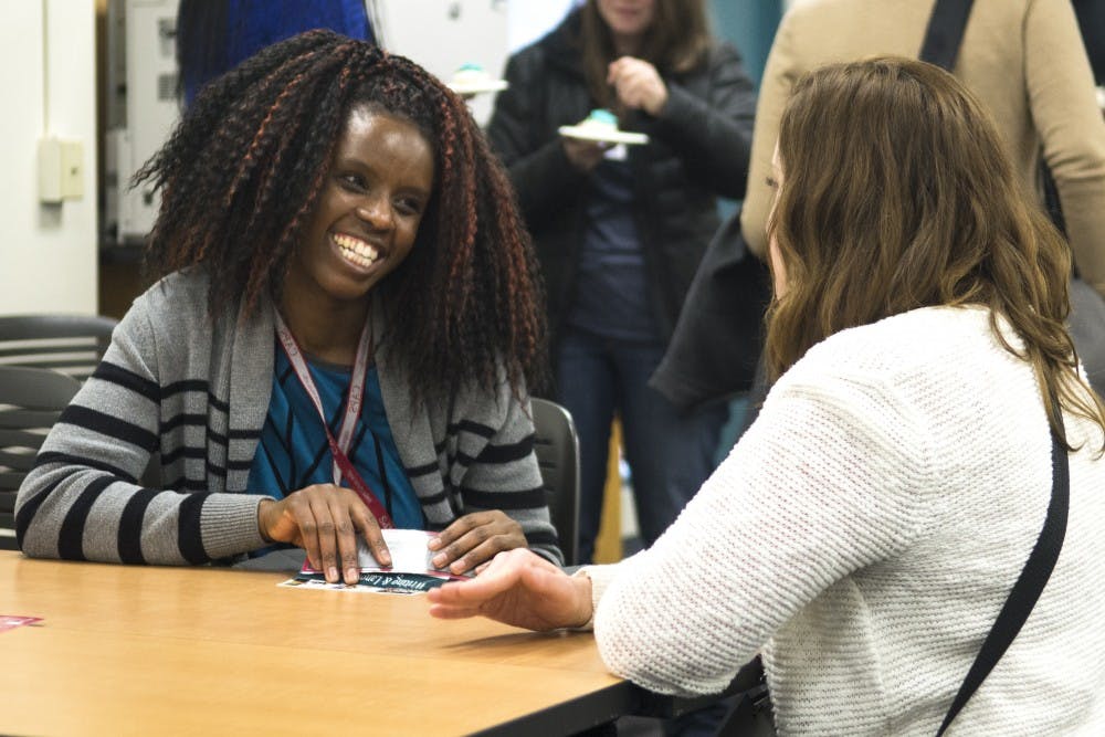 CAPS tutors Emillia Masaka (right), a third-year Ph.D. student, and Tana Moore (left), a speech and hearing science student, chat during the grand opening of the CAPS Writing and Language Center on Wednesday. The center, located in Education classrooms 208 and 210, helps students with writing and foreign languages.