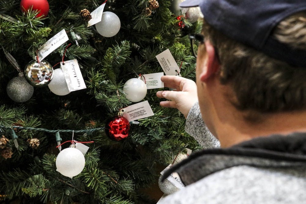 A UNM student checks out one of the Giving Tree ornaments in the UNM SUB on Nov. 27, 2017.