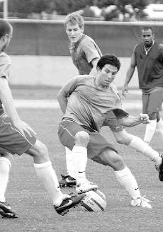 Lobo midfielder Bryan Saijadi, center, attempts to dribble the ball past teammates at a team scrimmage Tuesday at Robertson Field